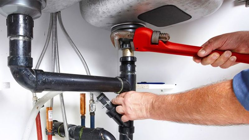 Kitchen plumber working on a pipe.