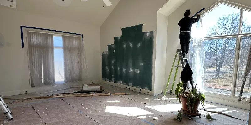 CrewPros remodeling putting up plastic to block dust.