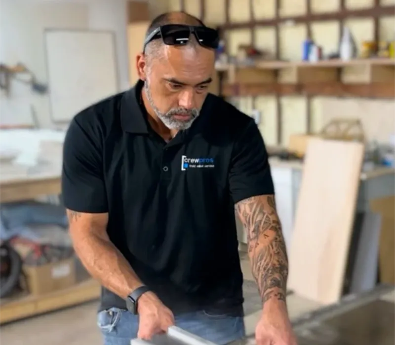 A CrewPros technician on site with a home repair cutting wood.