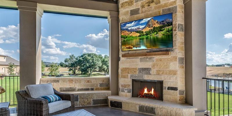 Outdoor remodel with sitting space, balcony, and a mounted television.
