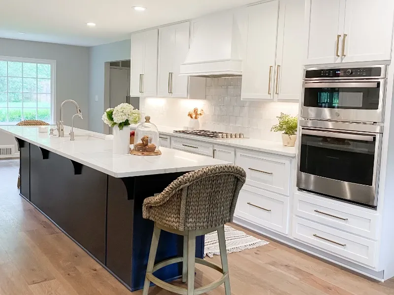 White kitchen featuring new wood floors and new cabinets.